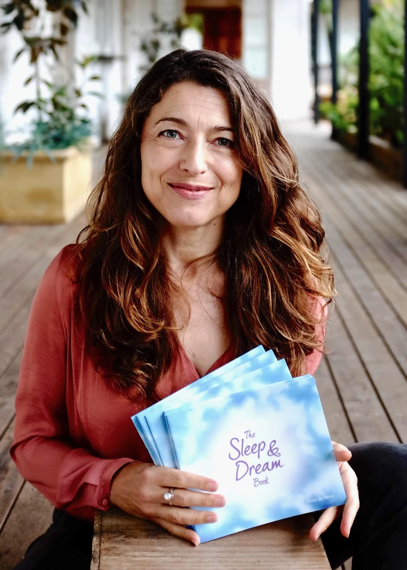 Ahna in 2017, smiling and holding copies of The Sleep & Dream Book